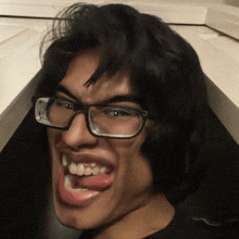 a man wearing glasses making a funny face with his tongue sticking out