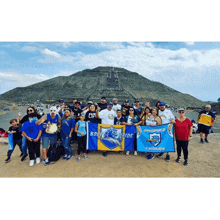 a group of people standing in front of a mountain holding a flag that says " bolt pride "