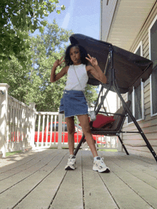 a little girl giving a peace sign while standing on a porch