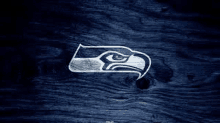 a seahawks logo on a wooden background .