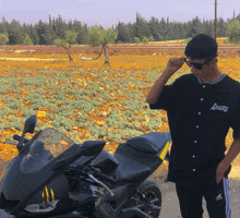 a man standing next to a motorcycle wearing a lakers shirt