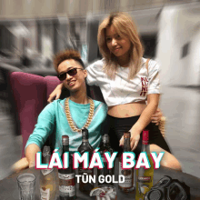 a man and a woman are sitting at a table with bottles of alcohol and the words lai may bay tun gold on the bottom