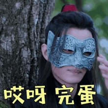 a man wearing a silver mask with chinese writing on it