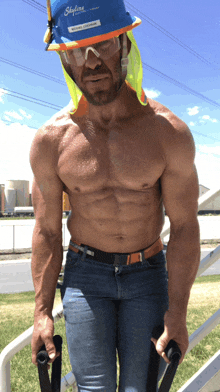 a shirtless construction worker wearing a blue skyline hard hat