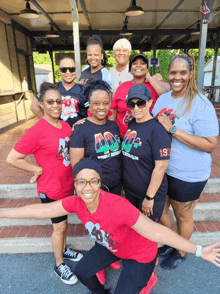 a group of women posing for a picture with one wearing a shirt that says 197