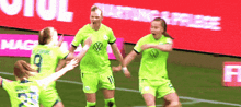 a group of female soccer players are celebrating a goal in front of a sign that says " starting free "