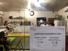 a sign that says aceitamos pagamento com is taped to a glass door