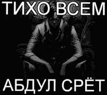 a black and white photo of a man sitting in a chair with a caption in russian .