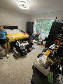 a woman in a blue shirt that says ' i love you ' on it stands in a messy room