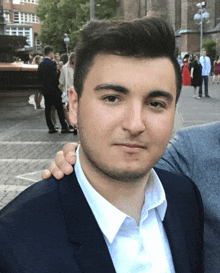 a man in a suit and white shirt is posing for a photo