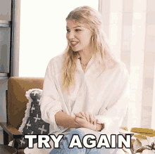 a woman in a white shirt is sitting in a chair with the words " try again " above her