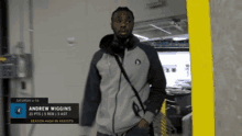 a man wearing headphones and a jacket with the name andrew wiggins on the front