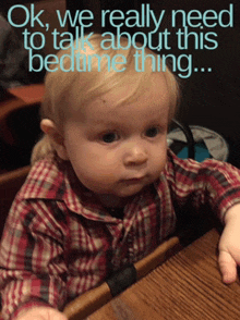 a baby in a plaid shirt is sitting at a table with the words ok we really need to talk about this bedtime thing