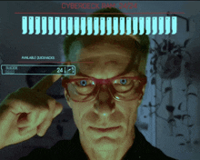 a man wearing glasses is looking at a screen that says cyberdeck ram 24/24 on it