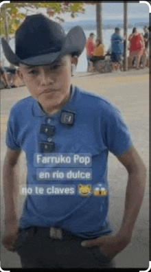 a young man wearing a cowboy hat and a blue shirt with the words farruko pop en rio dulce no te claves