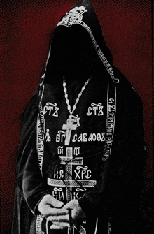 a black and white photo of a man wearing a hooded sweatshirt with a cross and the letters ctz on it