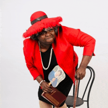 a woman in a red hat is holding a book and a fan