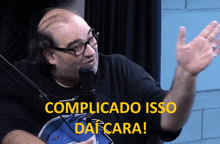 a man talking into a microphone with complicatado isso da cara written on the bottom