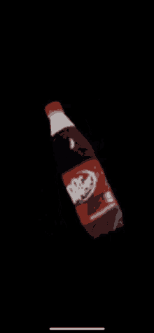 a bottle of pepsi is floating in the air with a black background