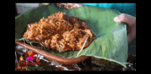 a person is holding a plate of food with a sign that says el recorrido de mi huasteca on it