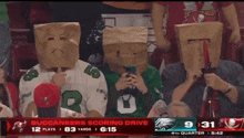 a group of people wearing paper bags on their heads are watching a buccaneers game