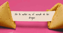 a fortune cookie says no te metas en el mundo de las drogas on a pink background