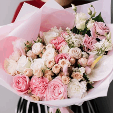 a woman holding a bouquet of pink and white flowers