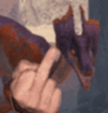 a person is giving a middle finger in front of a dragon .