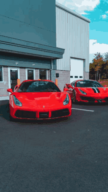 two red sports cars are parked in a parking lot