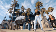 a group of people are posing for a picture in front of a stadium that says ' angels ' on it