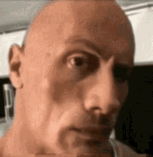 a close up of a man 's face with a bald head and a serious look on his face .