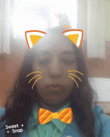 a girl wearing a bow tie and cat ears has a sweet snap sticker on her face