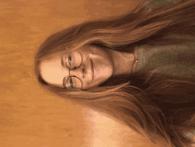 a woman with long red hair wearing glasses