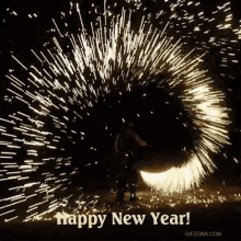 a man is standing in front of a fireworks display with the words `` happy new year '' written on it .