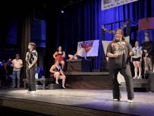 a woman in a taylor swift shirt is dancing on stage