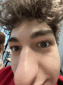 a close up of a person 's face with a red shirt