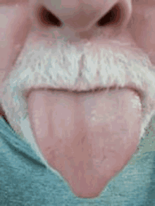 a close up of a man 's mouth with his tongue out .