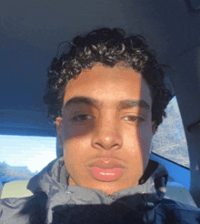 a young man with curly hair is taking a selfie