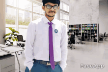 a man in a white shirt and purple tie is standing in an office with faceapp written on the bottom right