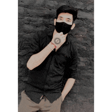 a man wearing a black shirt and a mask has a tattoo on his hand that says ' nv ' on it