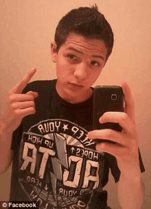 a young man is taking a selfie with a cell phone .