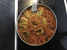 a pan of food with tomatoes and peppers on a stove