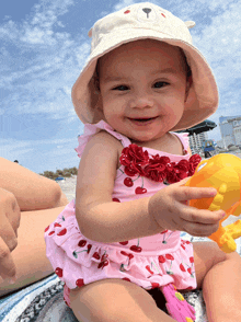 a baby wearing a hat and a pink swimsuit