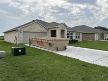 a large brown dumpster is parked in front of a house