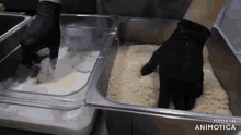 a person in a black glove is dipping a shrimp in a container of bread crumbs