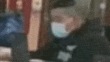 a man wearing a mask is standing in a blurry photo .