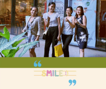 a group of women standing in front of a sign that says smile 3