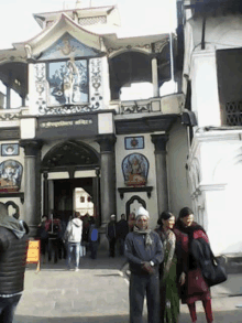 a group of people are standing in front of a building that says ' temple ' on the front