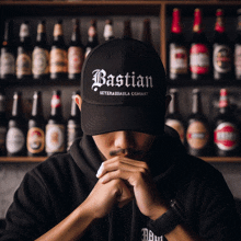 a man wearing a bastian hat stands in front of a shelf full of beer bottles