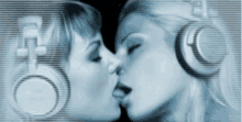 two women wearing headphones are kissing in front of a sign that says ' a ' on it